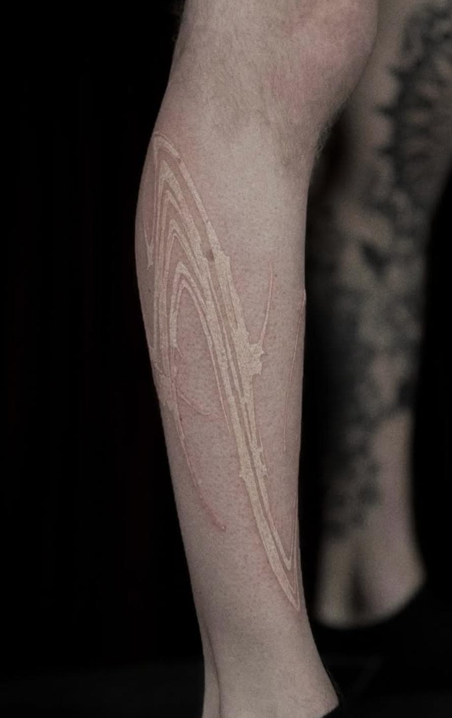 Subtle abstract line tattoo on calf