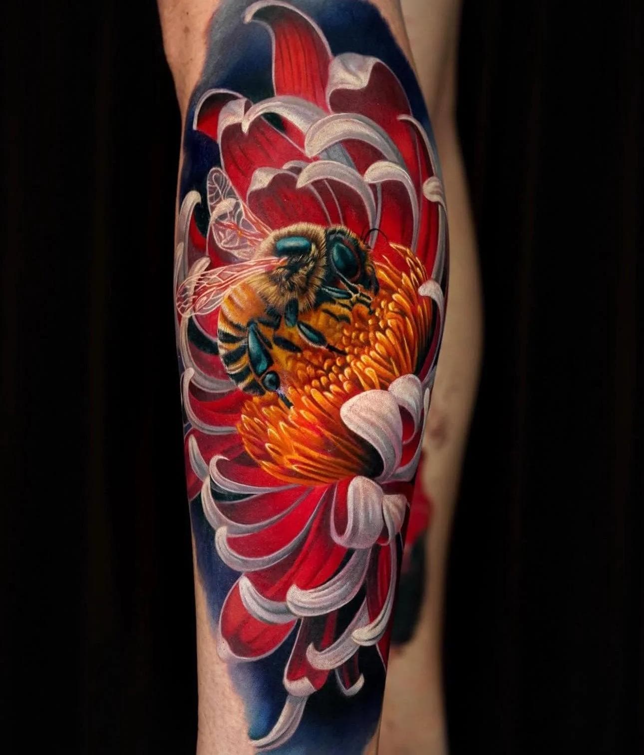Colorful realistic bee on a flower tattoo on calf