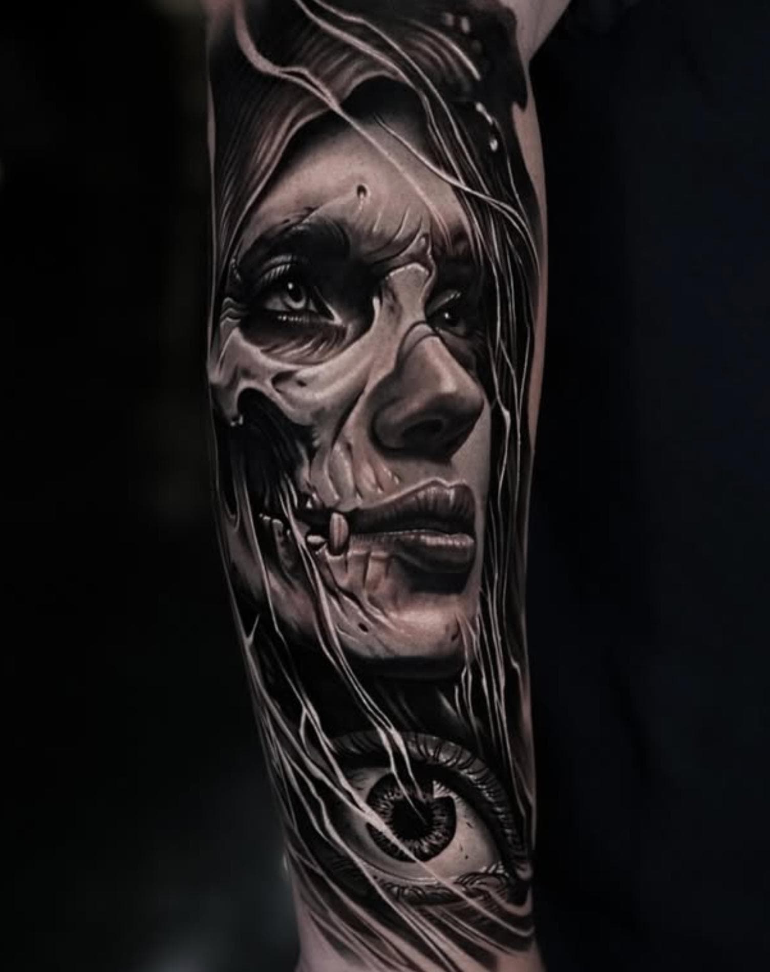 Black and grey realistic skull-faced woman tattoo on forearm