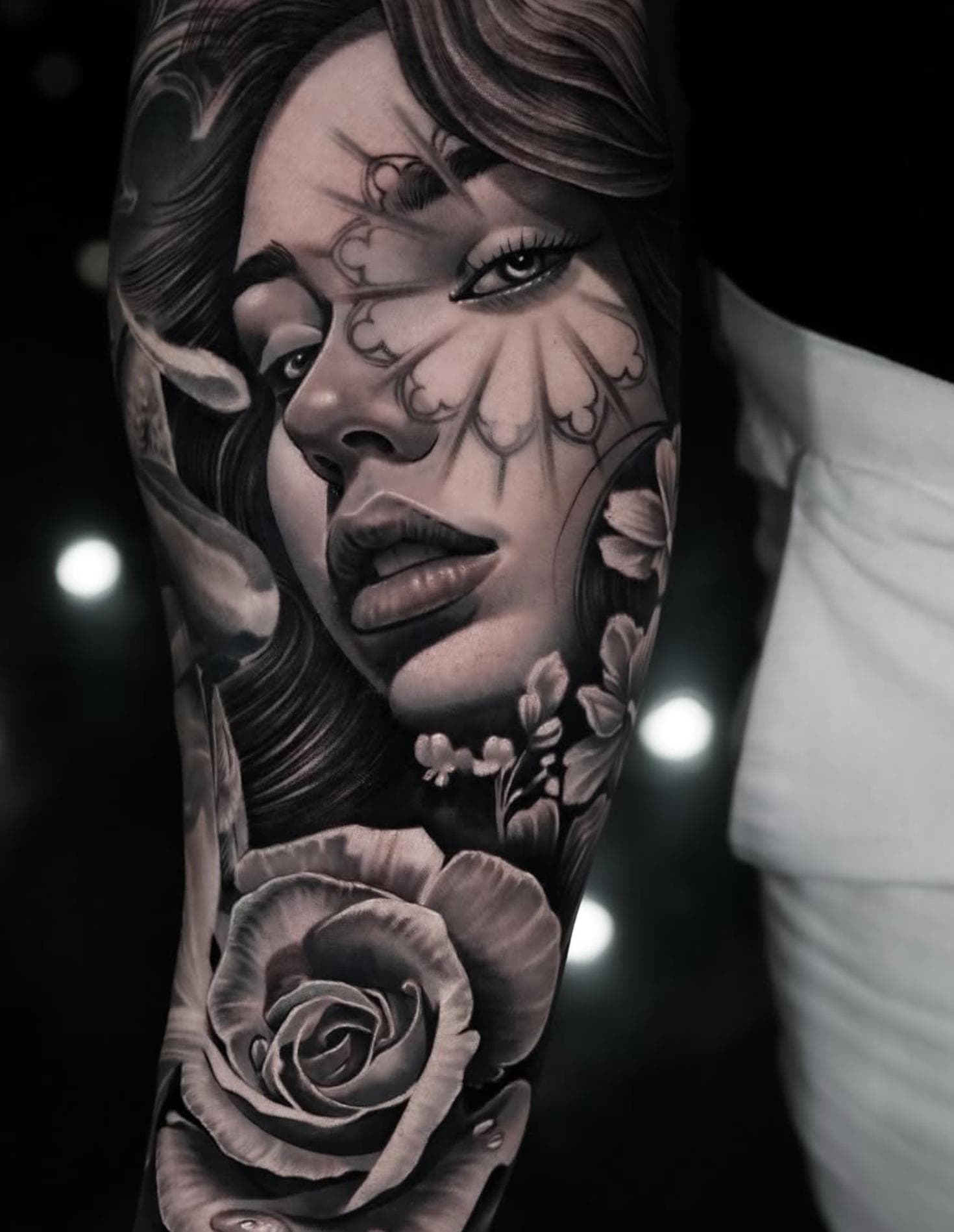 Black and grey realistic female portrait tattoo with ornamental design on forearm
