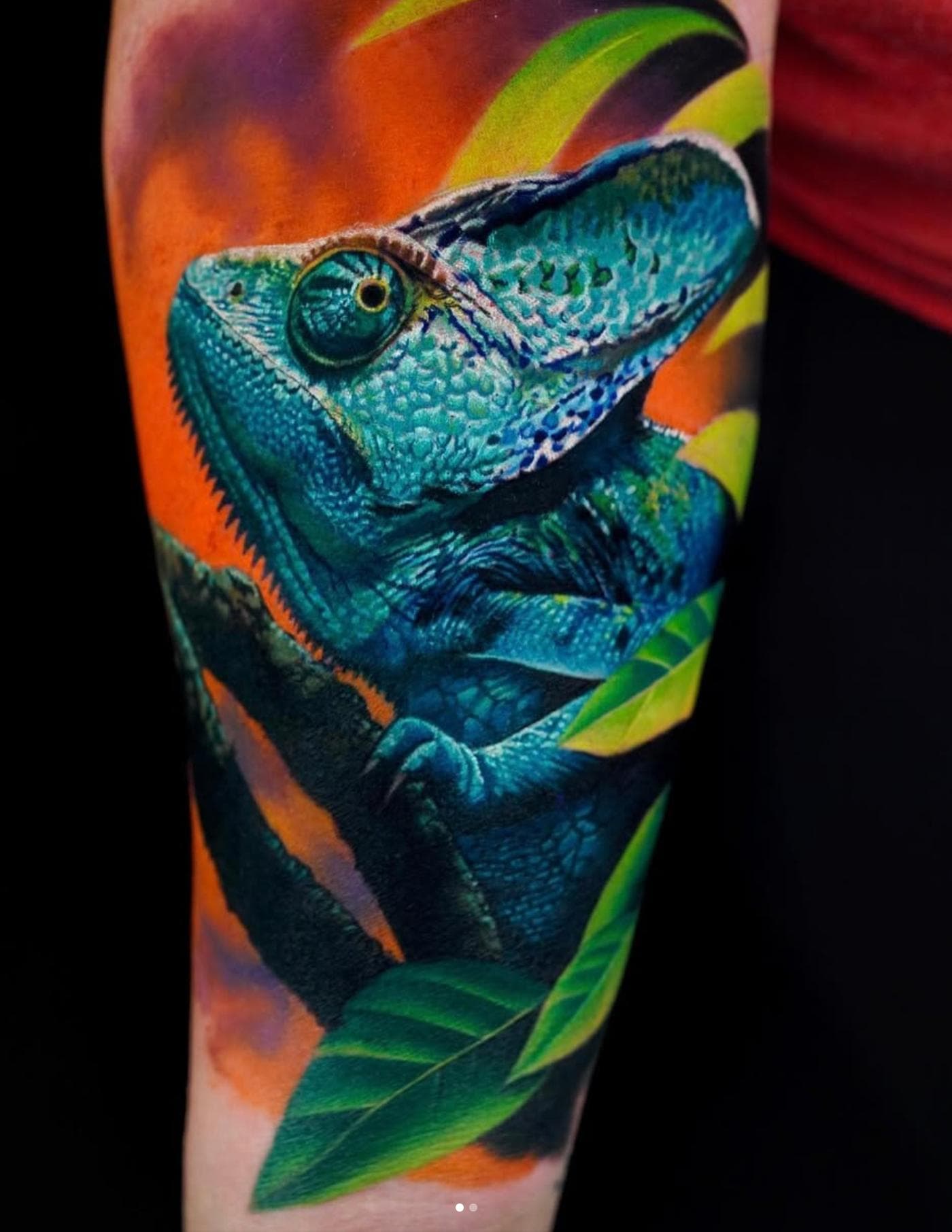 Vibrant color realistic chameleon tattoo on forearm
