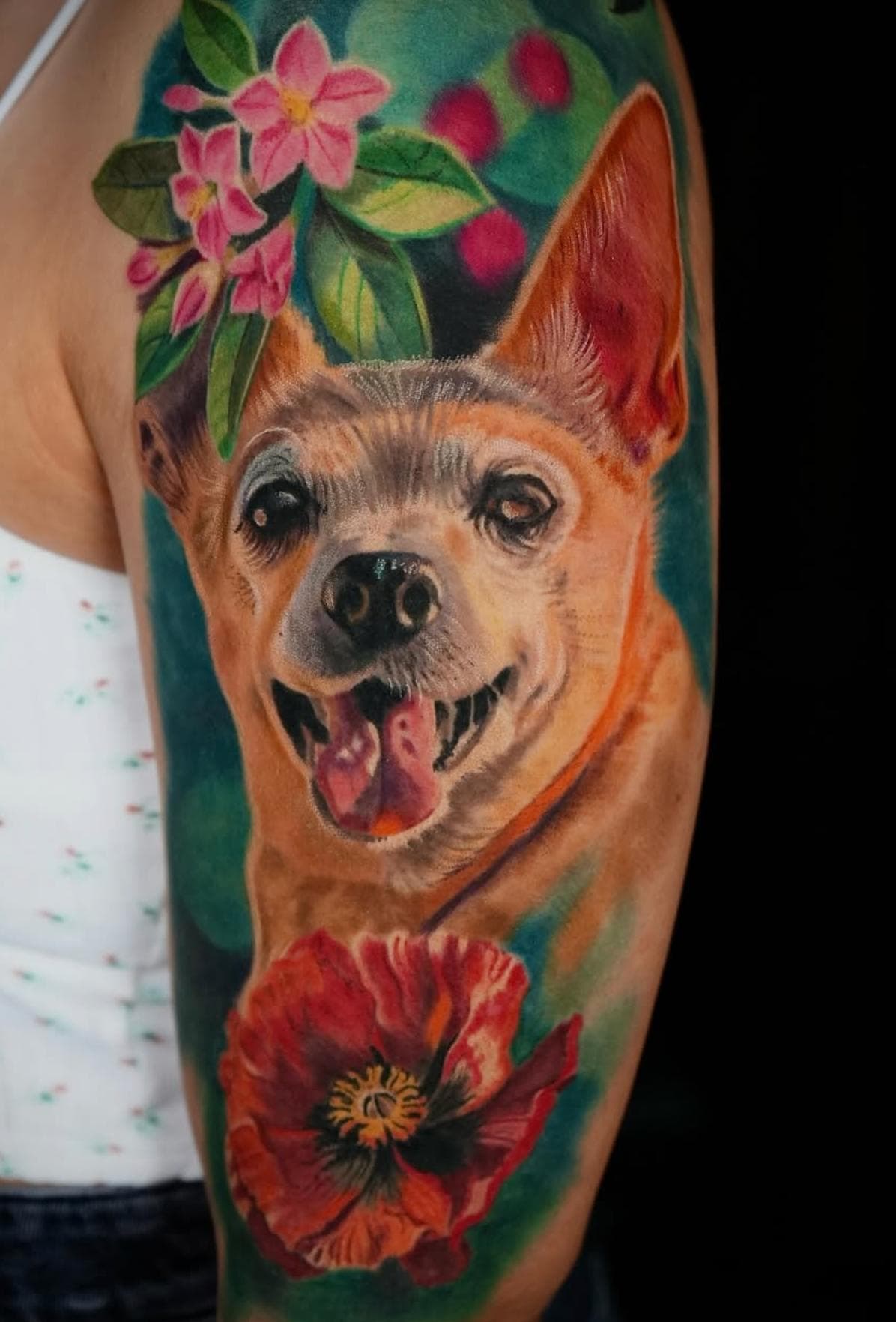 Colorful realistic dog and flower tattoo on upper arm