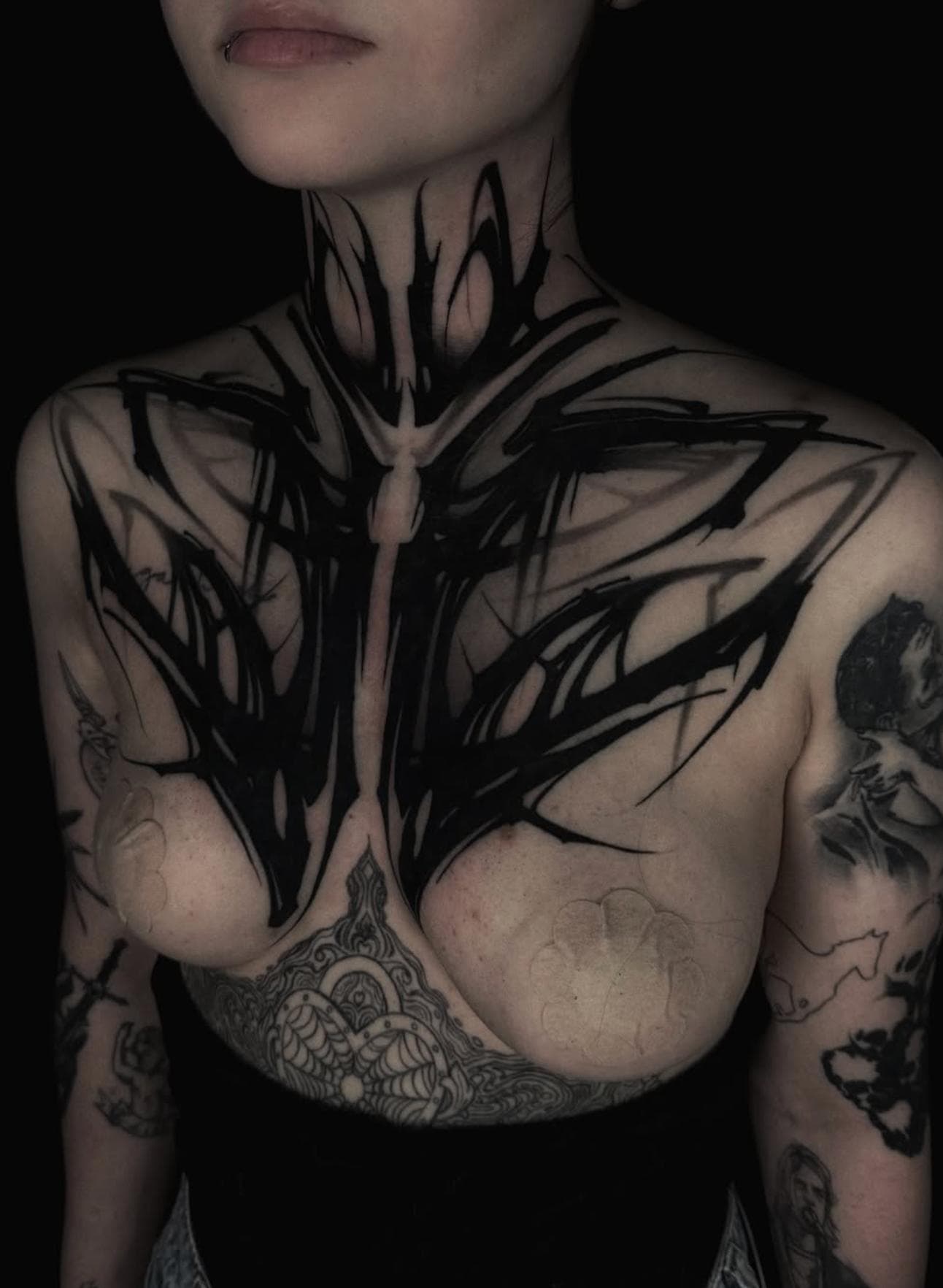 Abstract blackwork design covering the chest and neck